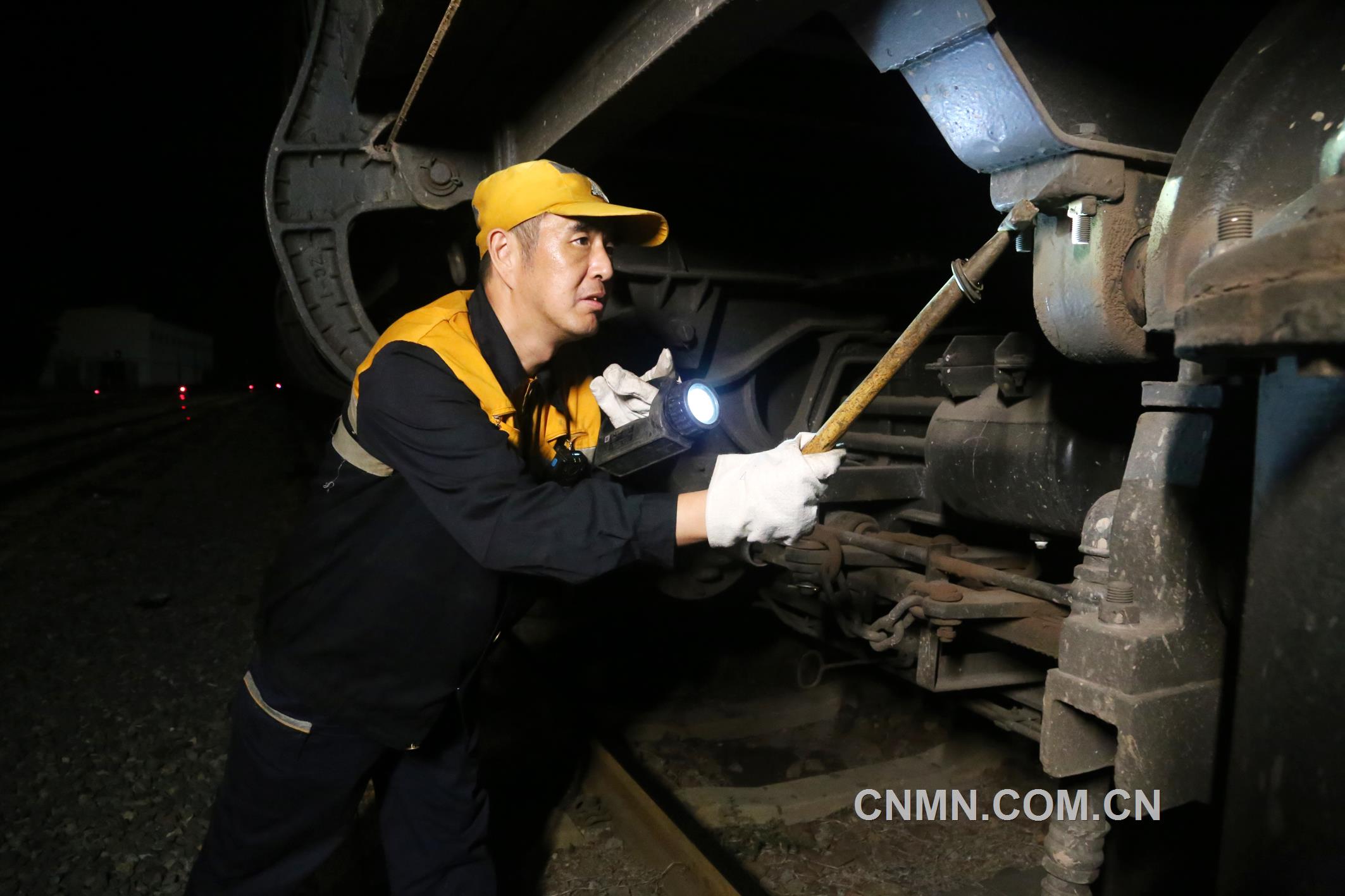 焦建智正在對(duì)待發(fā)礦石專列進(jìn)行發(fā)車前的技術(shù)檢查。